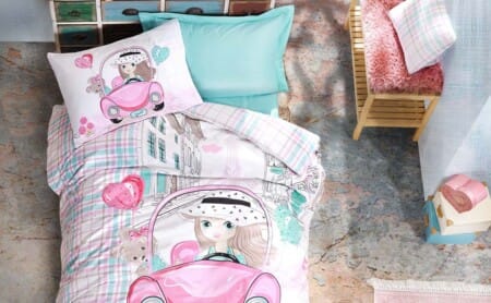a bed with a pink and blue comforter and pillows 
